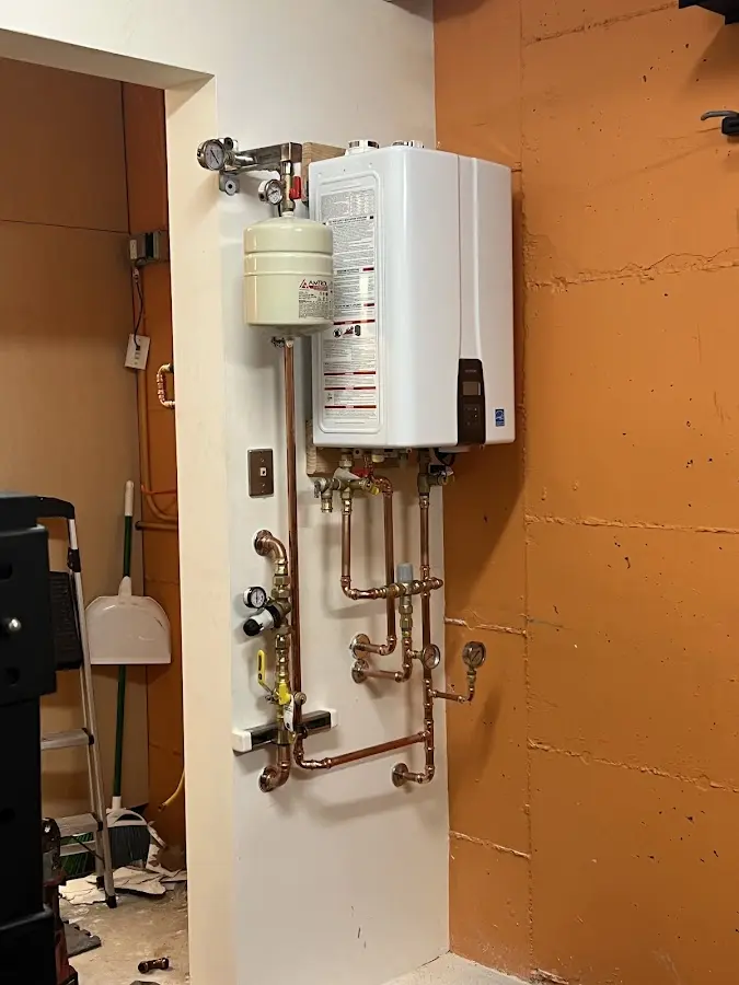 Plumbing technician inspecting water heater connections in Cranford